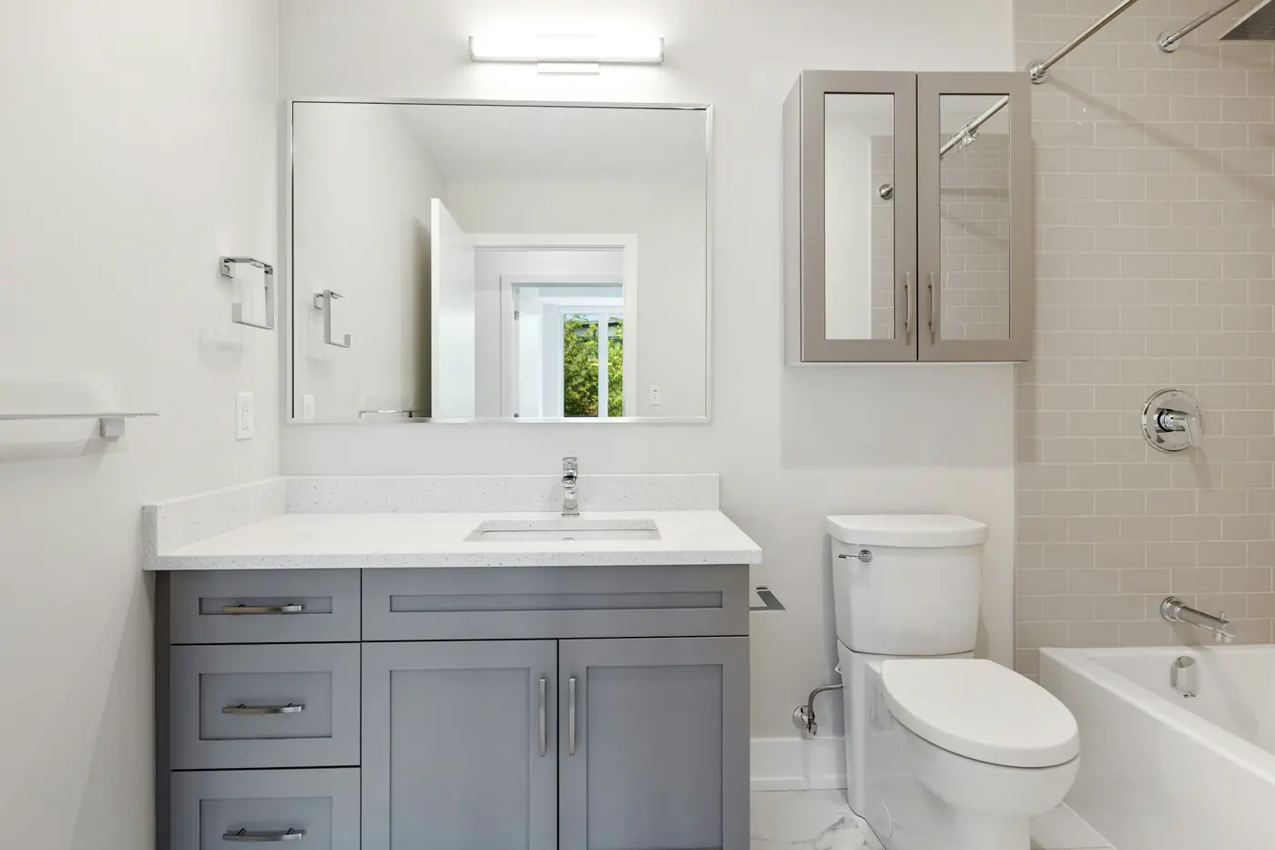 Bathroom with a grey vanity, toilet and bathtub