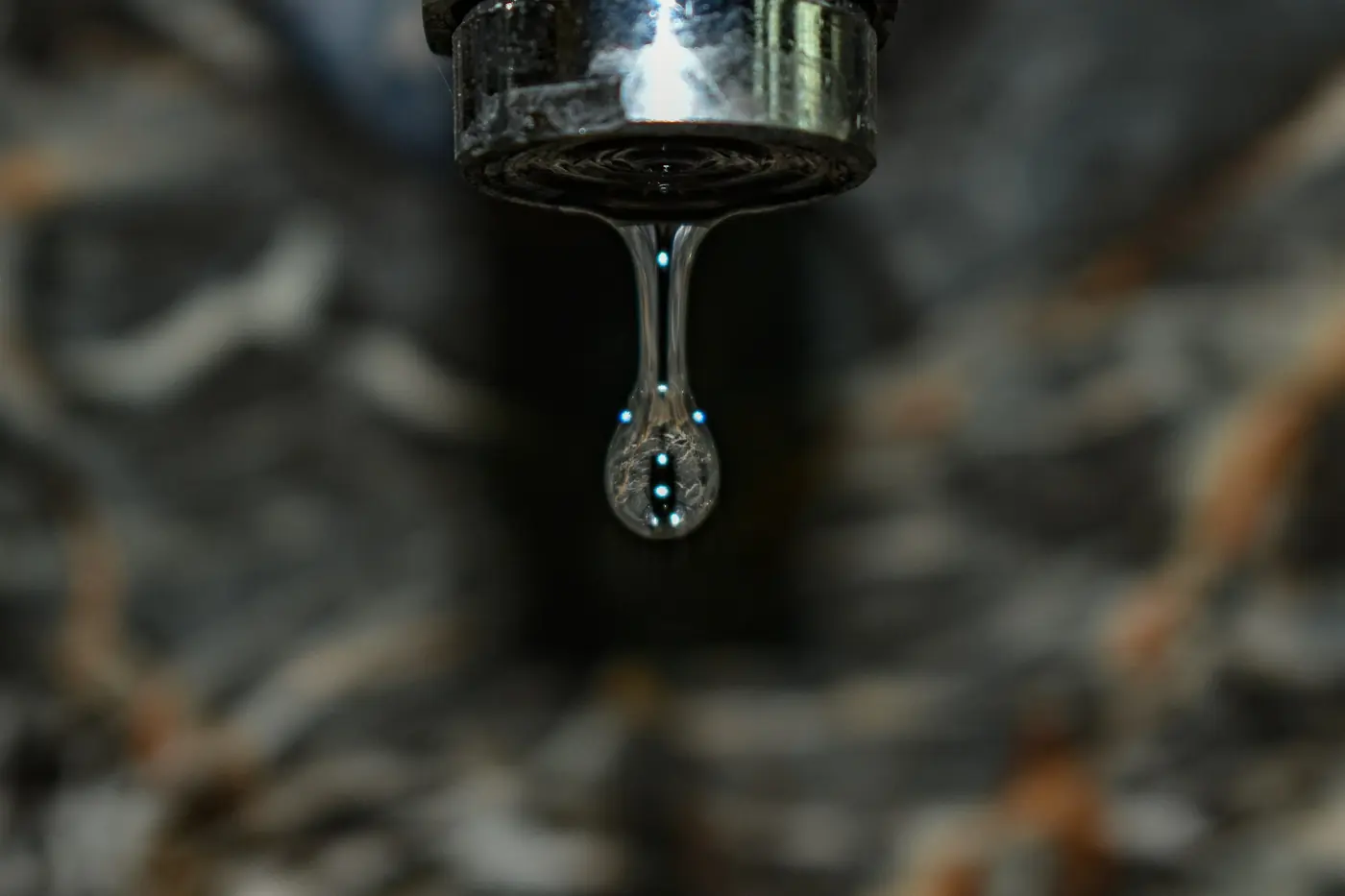 Water dripping from a chrome faucet
