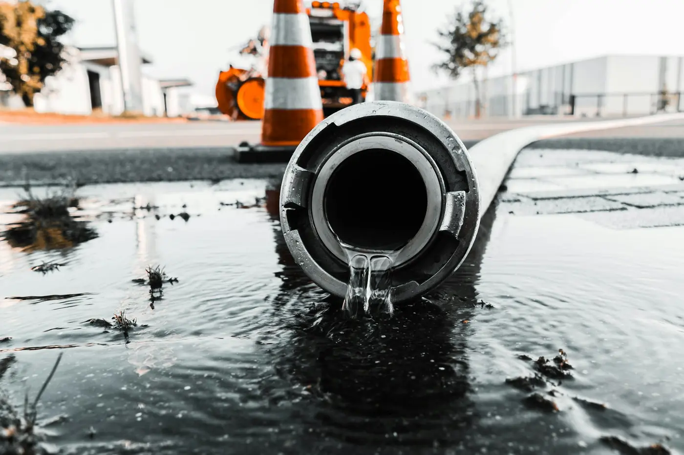 Water flowing out of a large grey pipe at street level