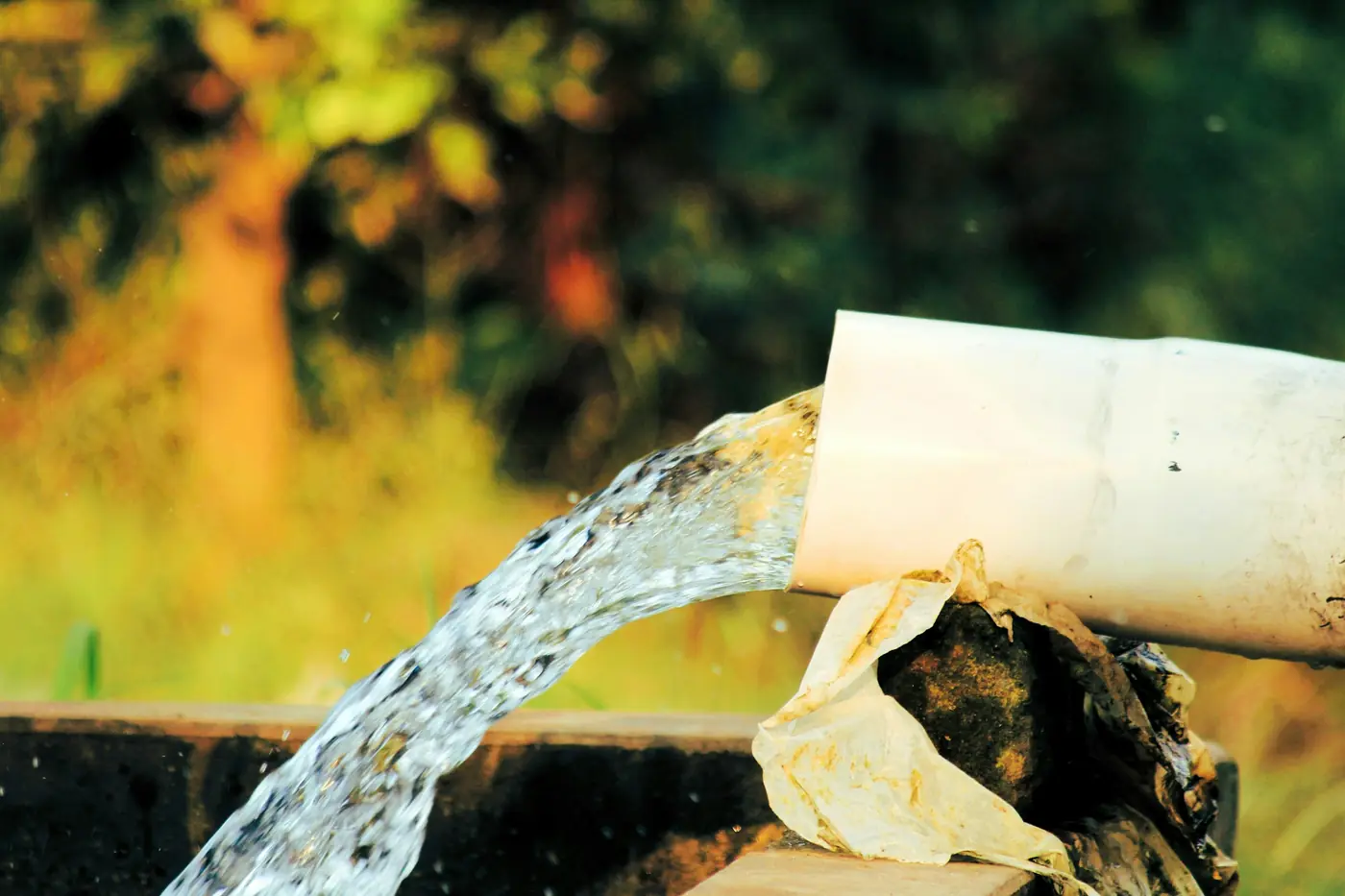 Strong stream of water gushing from a white pipe
