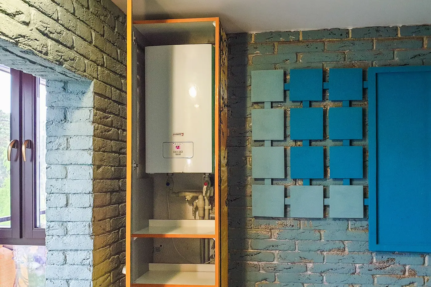 Grey electric water heater installed in a bathroom niche