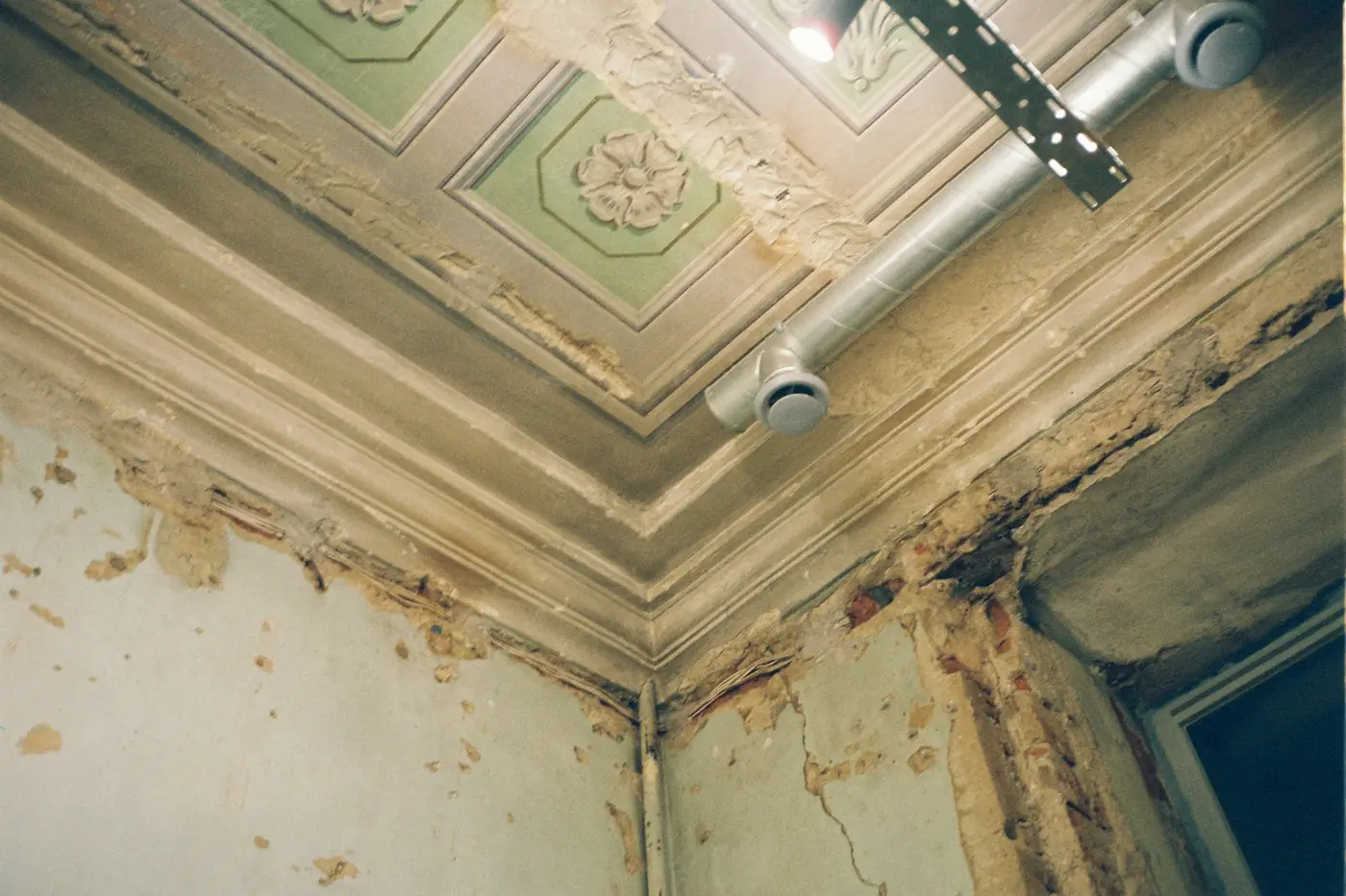 Water-stained ceiling corner with peeling paint