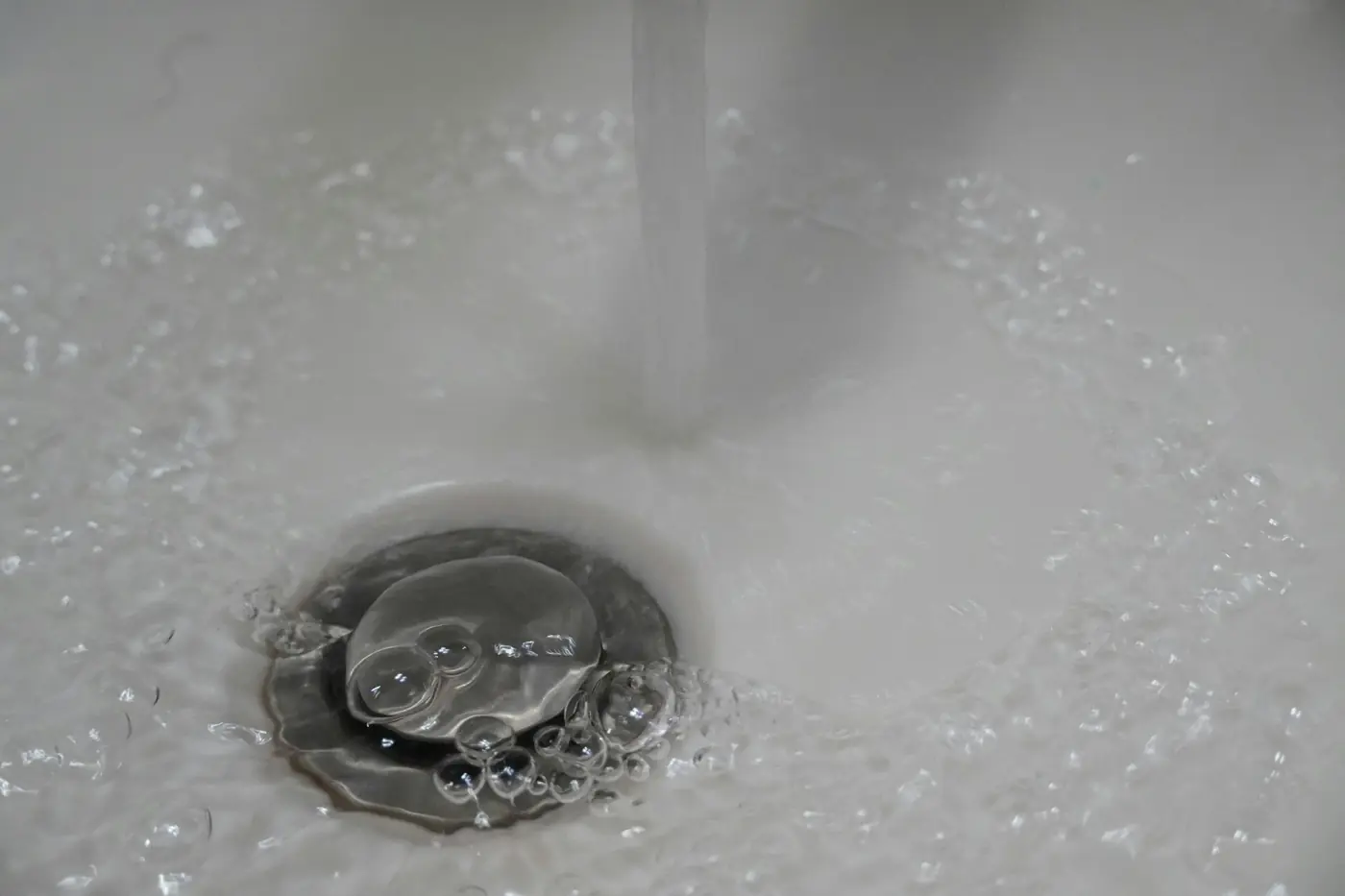 Water swirling into a white sink drain