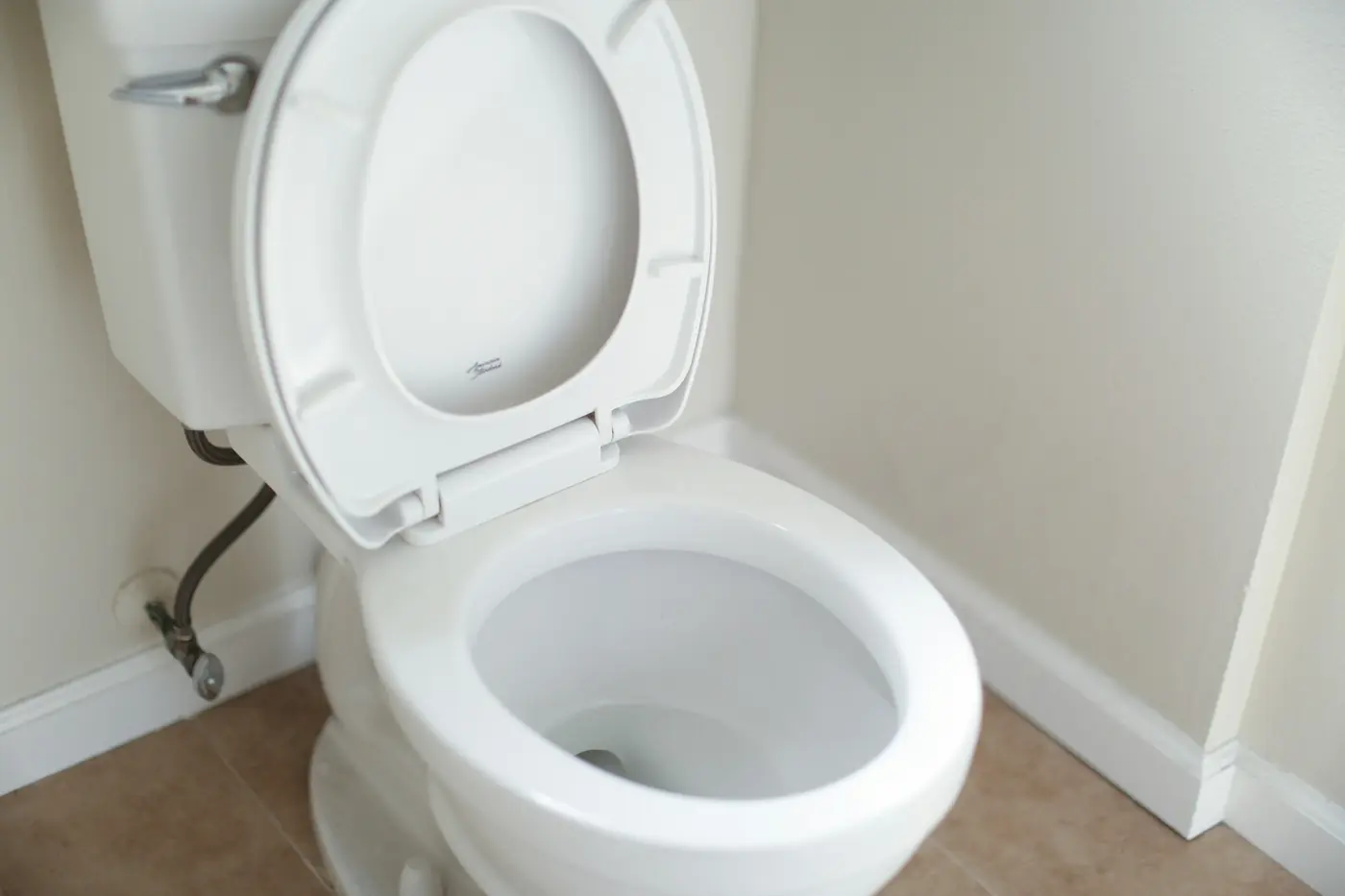 White ceramic toilet bowl with the lid open