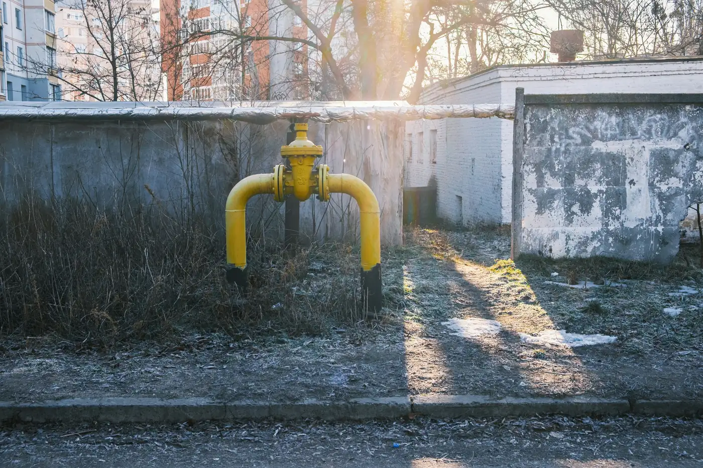 Yellow gas line with a shutoff valve outside a building